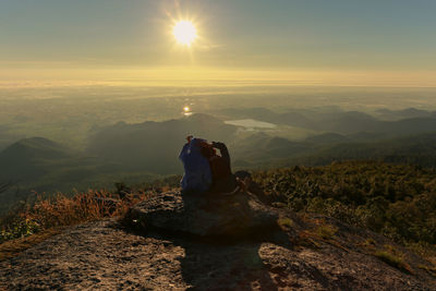 Rear view of man looking at mountain against sky