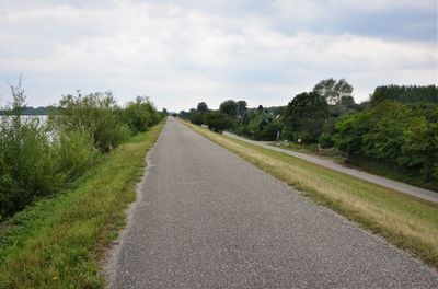 Road amidst trees against sky