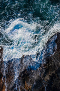 Aerial view of waves crashing on the rocks