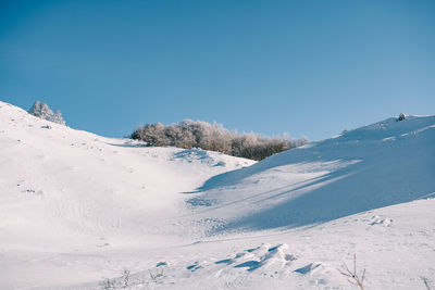 Scenic view of snowcapped mountains against clear blue sky