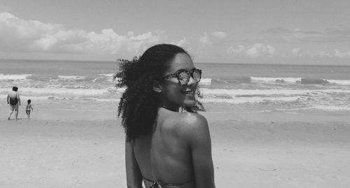 Portrait of beautiful woman at beach against sky