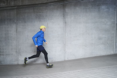 Mature man jogging in parking garage of residential building