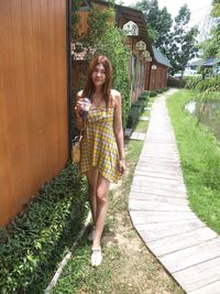 Portrait of a smiling woman standing against plants