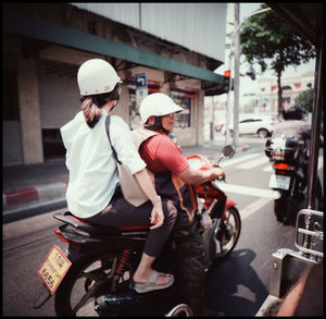 Rear view of people on street in city