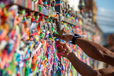 A catholic faithful is seen tying a souvenir ribbon on the railing of the senhor do bonfim church 