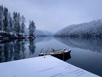 Boat on the lake in winter and trees covered in snow