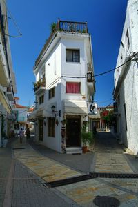 Narrow street in town against clear blue sky