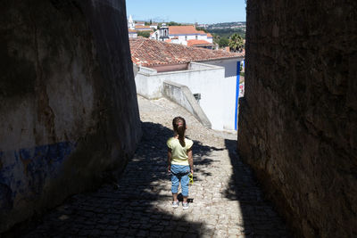 Rear view of girl standing on terrace in city