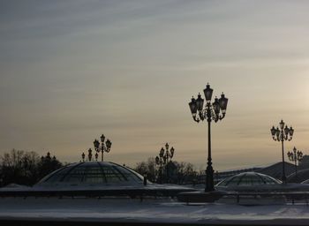 Cars on street against sky during sunset