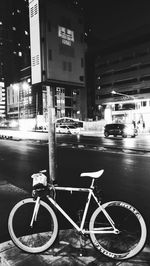 Bicycle parked on road at night