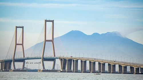 View of bridge over river against cloudy sky