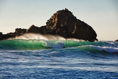 Scenic view of rocks in sea against sky