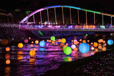 Illuminated bridge over river at night