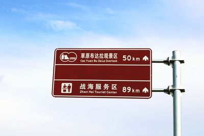 Low angle view of road sign against sky