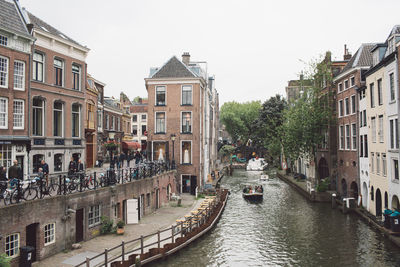 Canal amidst buildings against sky in city