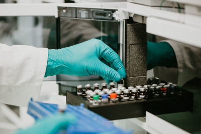 Cropped hand of scientist holding vial in laboratory