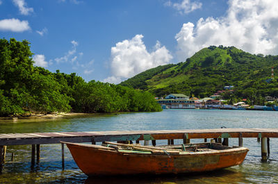 Boat moored by jetty in sea against sky