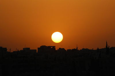 Silhouette buildings against sky during sunset