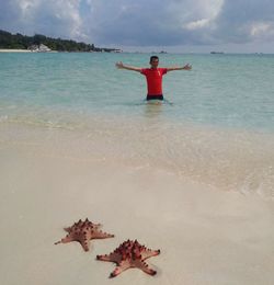 Man with red umbrella on beach