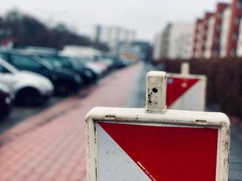 Close-up of red car on road against city