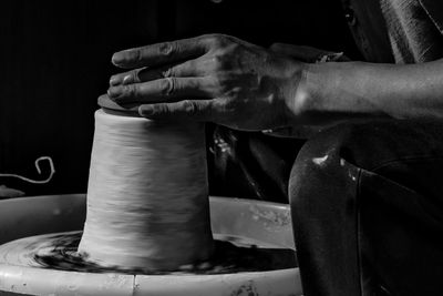 Midsection of man working on pottery wheel