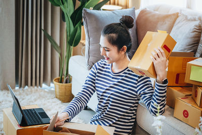 Portrait of woman using laptop while sitting on table