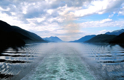 Scenic view of sea and mountains against sky