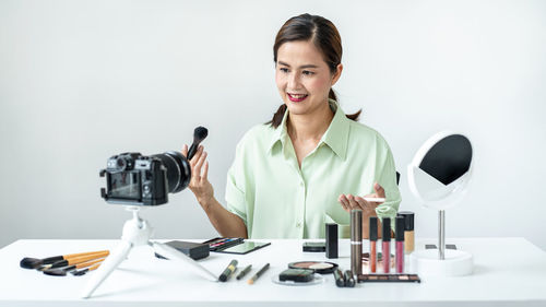 Portrait of young woman drinking wine in gym
