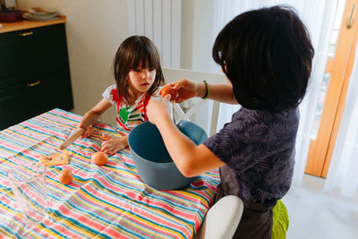 Side view of girl playing with daughter at home