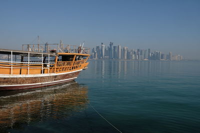 Scenic view of sea by buildings against clear sky