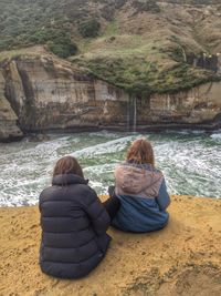 Rear view of women sitting at the lake