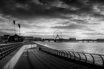 Pier over sea against cloudy sky