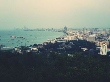 Cityscape by sea against sky