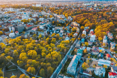 Aerial view of trees and buildings against sky at sunset