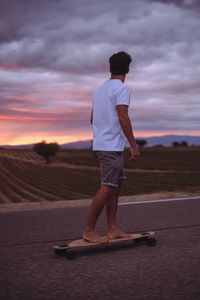 Rear view of man standing on skateboard