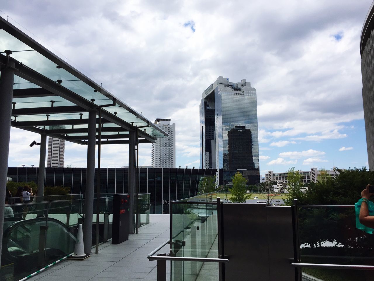 architecture, built structure, building exterior, city, skyscraper, tall - high, sky, tower, office building, low angle view, cloud, modern, cloud - sky, building story, city life, outdoors, development, day, cloudy, tall, leading, footpath, no people, urban skyline