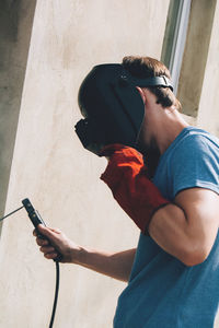 A man works in a protective mask with welding