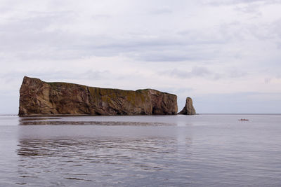 View of people in a kayak in the percé bay with the famous rock in the background