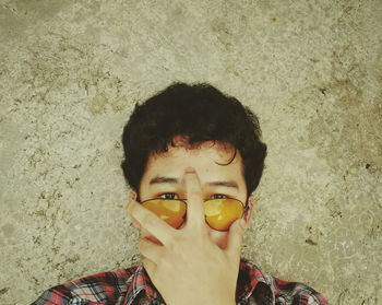 Portrait of boy wearing sunglasses against wall