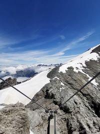 Scenic view of snowcapped mountains against blue sky