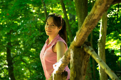 Side view of a smiling young woman in forest