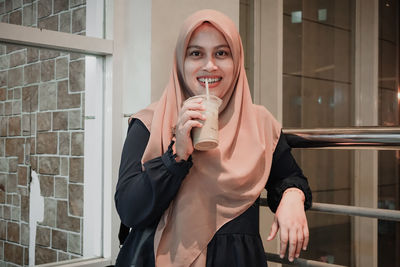 Portrait of a smiling young woman holding food