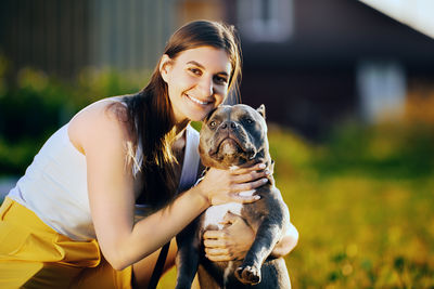 Side view of young woman holding turtle