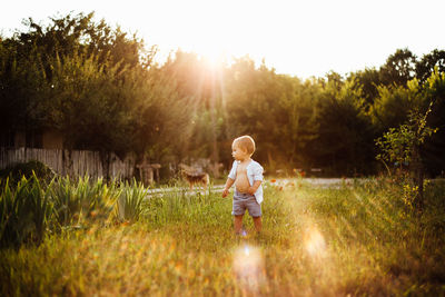 Full length of boy standing on land against sky