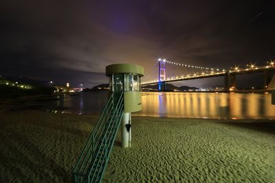 Illuminated bridge against sky at night