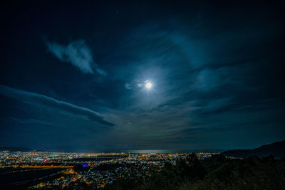 Aerial view of illuminated city against sky at night