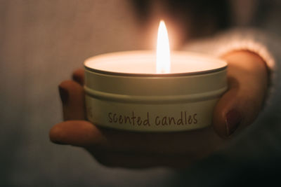 Midsection of woman holding lit tea light candle