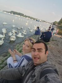 Young couple looking at sea against sky