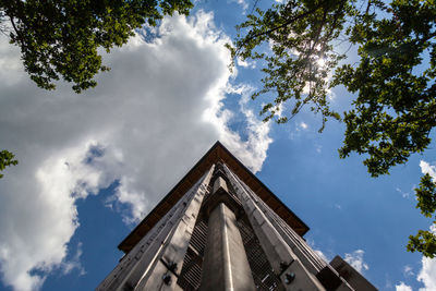 Low angle view of trees and building against sky