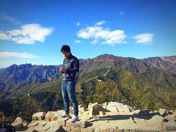 Full length of woman standing on mountain landscape